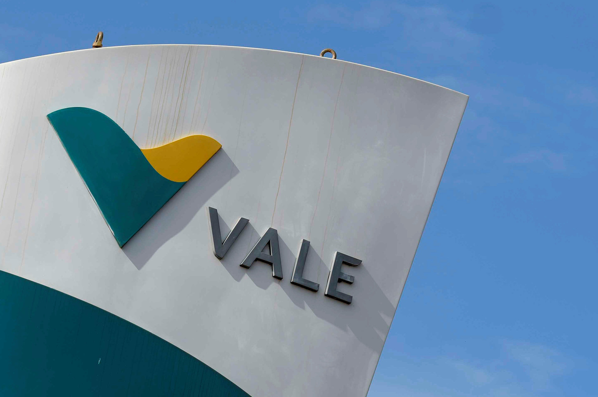 Logotipo grande da VALE com V estilizado em verde-azulado e amarelo sobre fundo branco e céu azul.